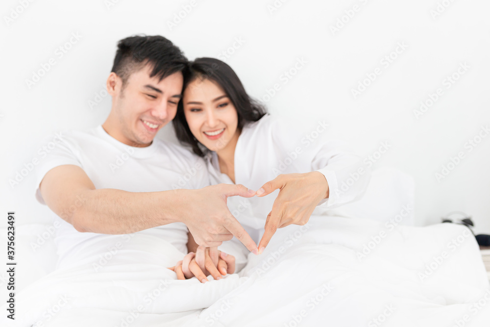close up hands, Asian lover show heart sign with hand, they feeling happy and smiling, they rest on bed, happiness honeymoon close up hands, Asian lover show heart sign with hand, they feeling happy and smiling, they rest on bed, happiness honeymoon