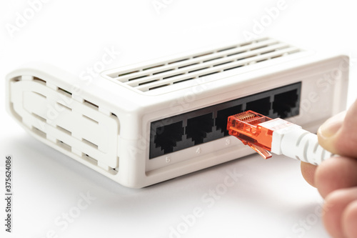 A white utp cable with a red convector is inserted into the white switch. photo