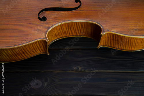 The cello lies on a wooden surface. Place for text