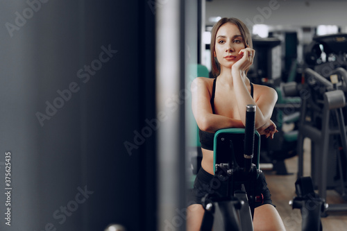 Young beautiful woman training her arms in a gym apparatus