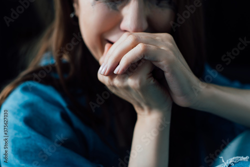 cropped view of depressed woman crying at home