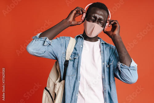 Young man in medical mask and headphones