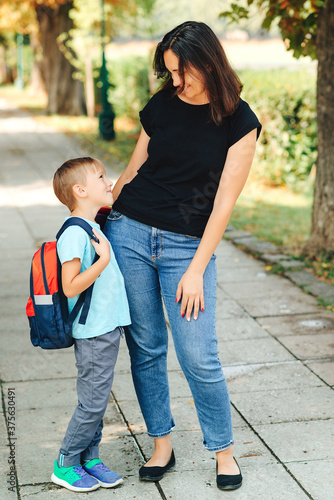 Fototapeta Naklejka Na Ścianę i Meble -  Happy boy and mother going to school together. First day of school.
