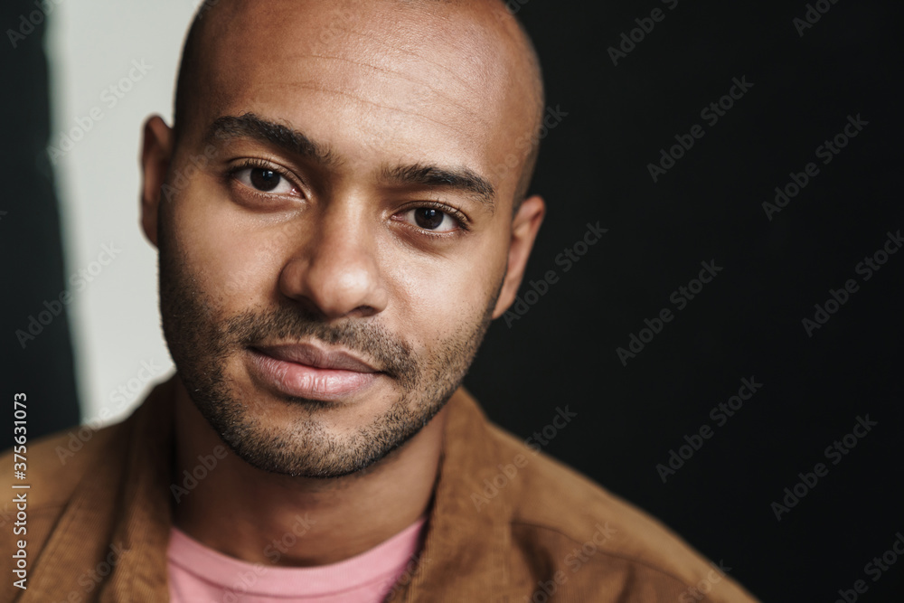 Fototapeta premium Image of pleased african american guy looking at camera