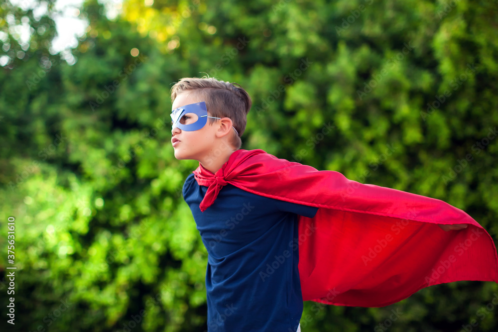 Superhero kid against green background outdoor. Childhood, success and and power concept Superhero kid against green background outdoor. Childhood, success and and power concept