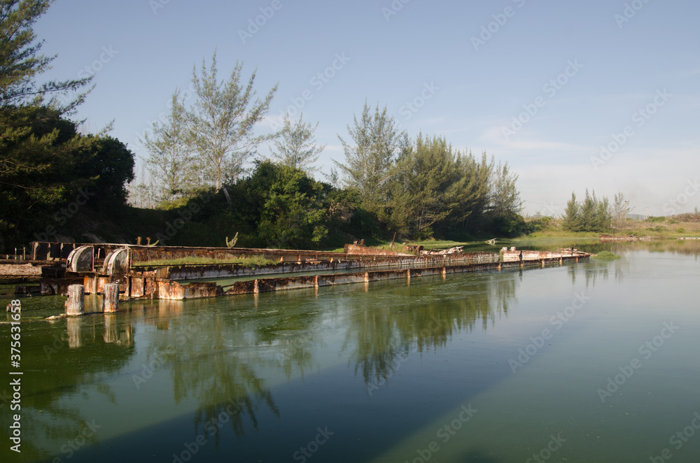 Old abandoned shell barge rusting in salt water. Old abandoned shell barge rusting in salt water.