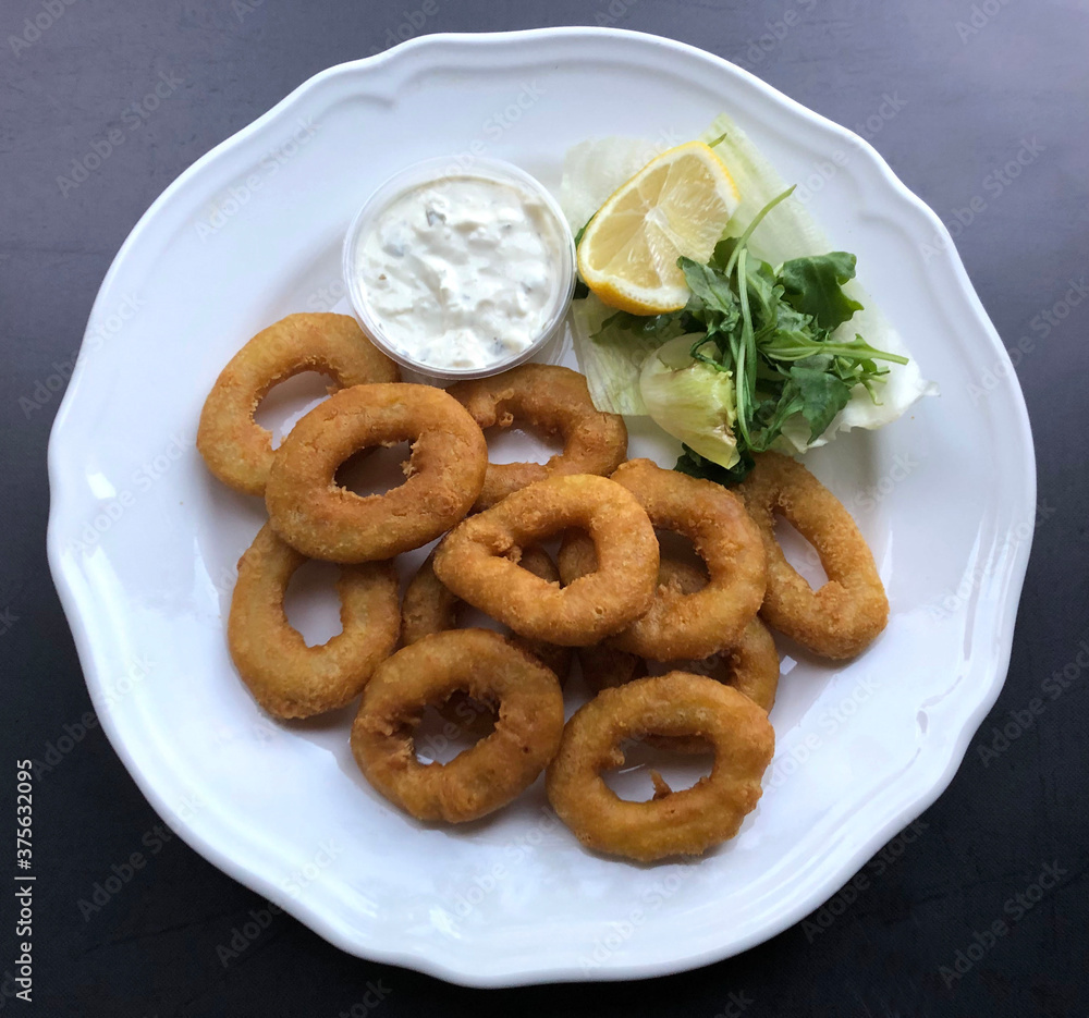 Crispy deep fried Calamari with sauce tartare. Fried squid rings is a seafood appetizer. Crispy deep fried Calamari with sauce tartare. Fried squid rings is a seafood appetizer.