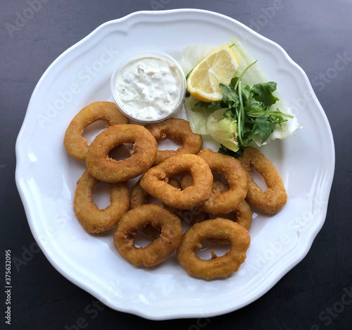 Crispy deep fried Calamari with sauce tartare. Fried squid rings is a seafood appetizer. photo