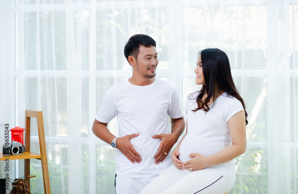 Fototapeta premium The pregnant woman is happy with her husband, preparing to watch the child who is about to give birth.