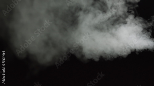 White water vapour on a black background. Close-up shot. White Fume Slowly Floating Rises Up. Abstract Haze Cloud. Animation Mist Effect. Smoke Stream Effect 4K