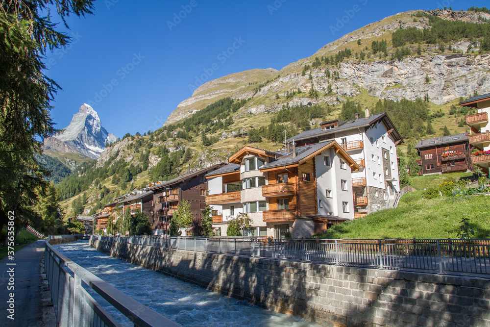 Zermatt with river Mattervispa, Matterhorn and typical houses in summer, Switzerland