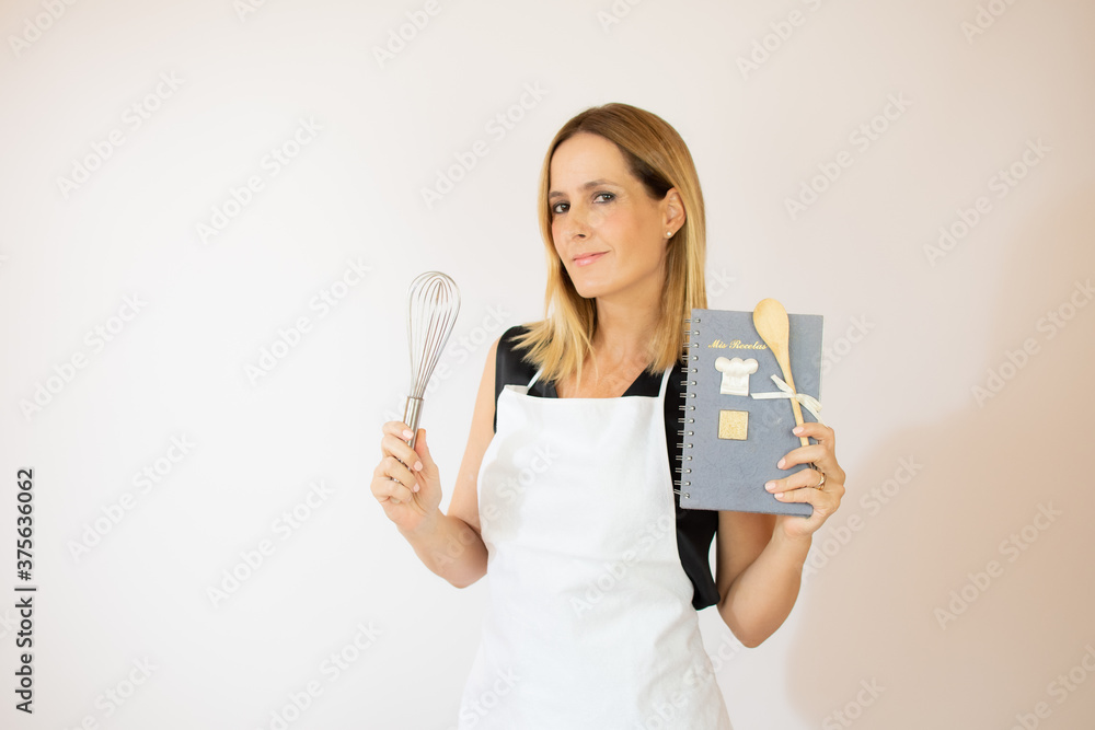 Smiling beautiful woman with apron and kitchen utensils Smiling beautiful woman with apron and kitchen utensils