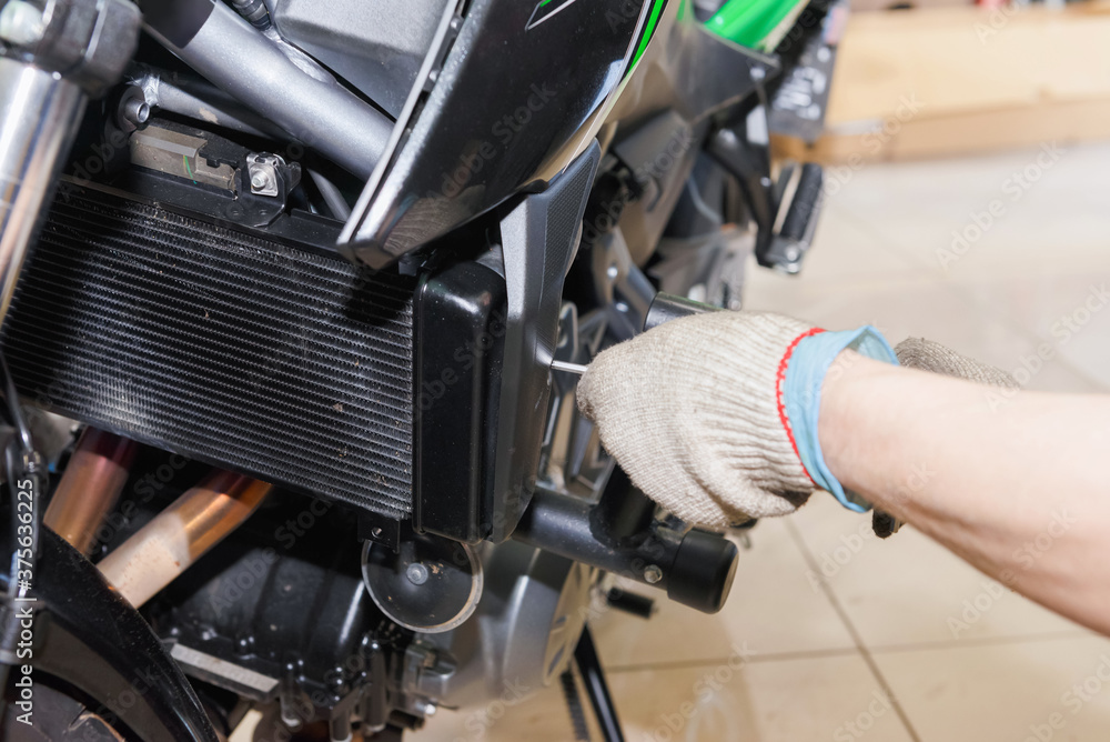 Fototapeta premium The master performs maintenance on the motorcycle.