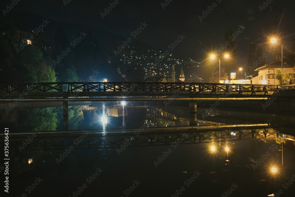Night city lights and autumn dawn at Miljacka river in Sarajevo, Bosnia and Herzegovina