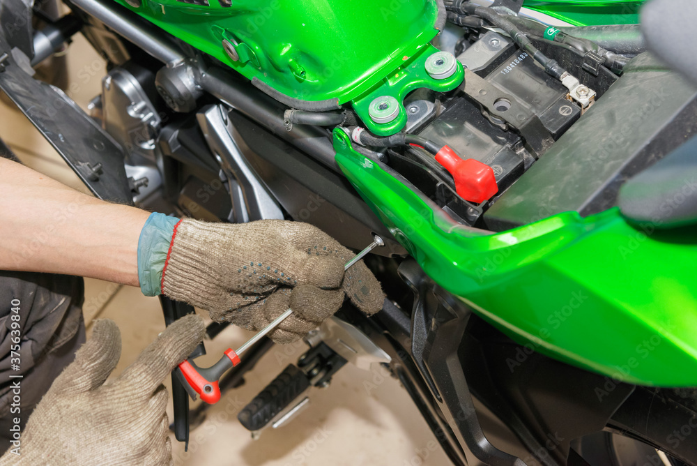 The master performs maintenance on the motorcycle. The master performs maintenance on the motorcycle.