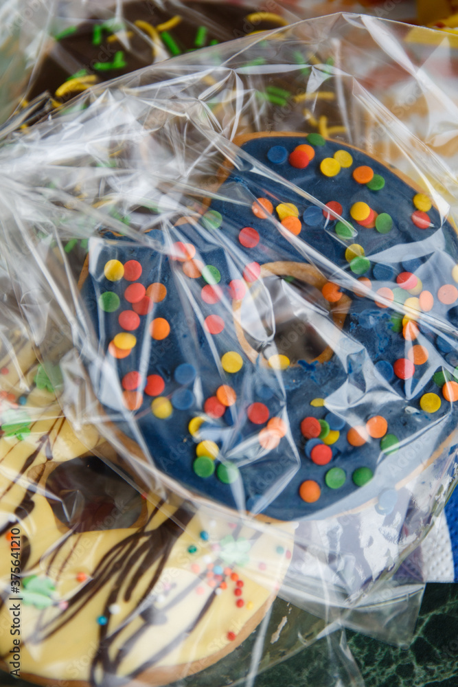 Fototapeta premium Large donut in blue-blue glaze with multi-colored sprinkles