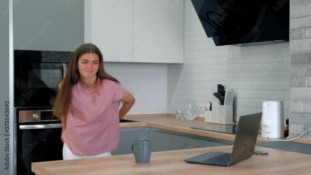 This video shows a teen girl playing a song on her laptop and dancing in her kitchen. This video shows a teen girl playing a song on her laptop and dancing in her kitchen.