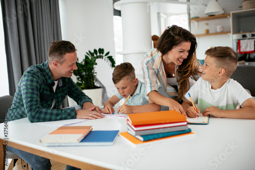 Parents helping the kids with their homework. Litlle boys learning at home..
