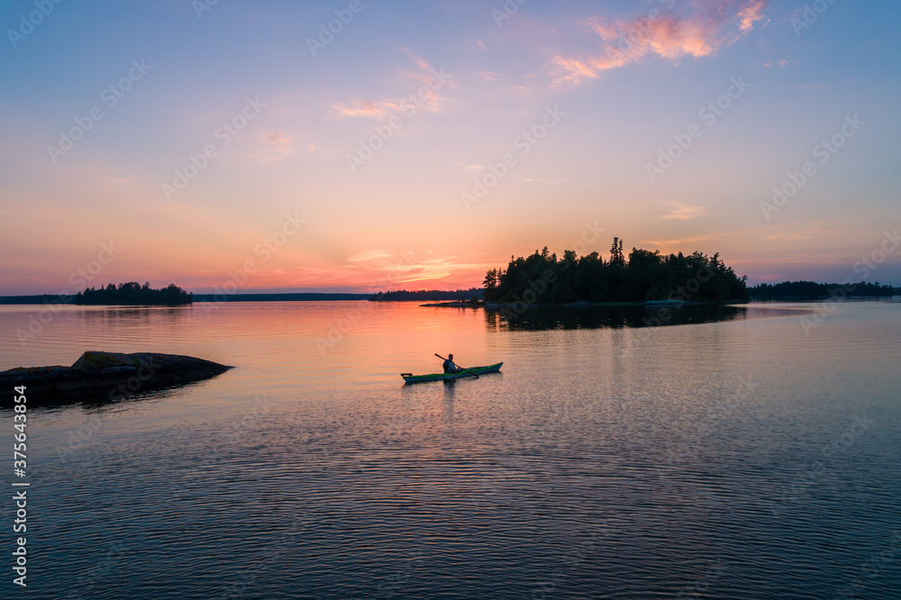 Kayaking at sunset on a quiet evening in Northwest Ontario, Canada.