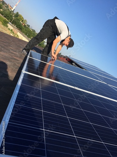 worker on a roof. solar power station. solar panels on the roof. man install solar panels