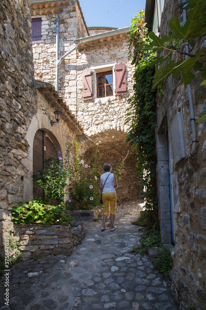 Femme touriste promenant dans les rue de Lagorce (Ardèche)