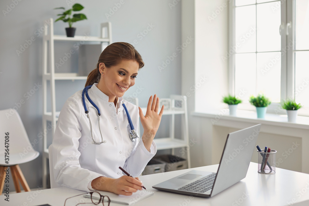 Happy female doctor talking to patient online through laptop. Friendly physician giving consultation to client on webcam Happy female doctor talking to patient online through laptop. Friendly physician giving consultation to client on webcam