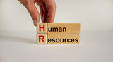 Wood cubes and blocks with words 'HR, human resources' on white background, copy space. Male hand. Business, employment and human resources conceptual image.