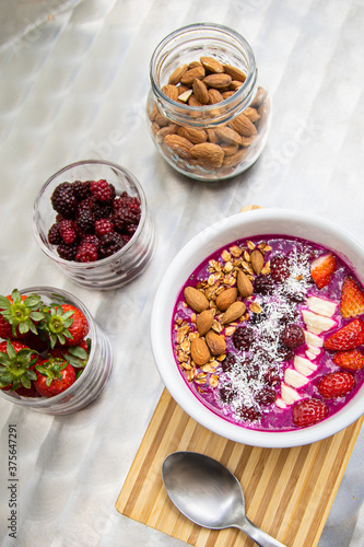 Dragon fruit smoothie bowl with berries and toppings, healthy breakfast cereal