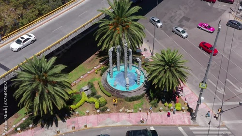 Snake like fountain in Mixcoac neighborhood in Mexico City between a busy street interjection photo