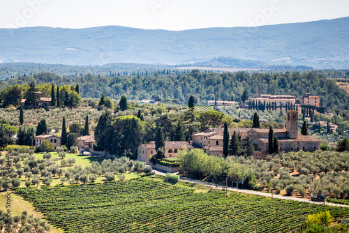 San Gimignano  Italy rolling hills with vineyards wineries and house villas landscape in town village during summer aerial high angle view with olive cypress trees