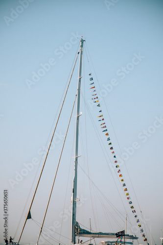 Mast of a big sailboat with flags hanging on it