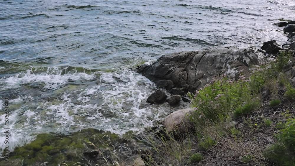 Beautiful slow motion view of waves Baltic Sea breaking against the stones. Gorgeous nature landscape view. Sweden.