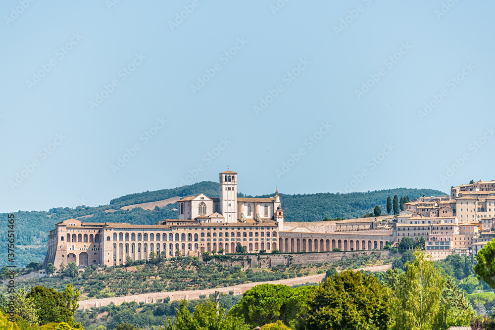 Village city of Assisi in Umbria, Italy cityscape of famous church during summer day landscape in Etruscan countryside