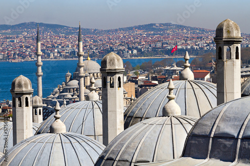 Bosphorus through the chimneys and domes of the ancient ottoman madrasa in Istanbul, Turkey.