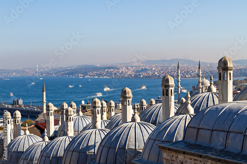 Bosphorus through the chimneys and domes of the ancient ottoman madrasa in Istanbul, Turkey.