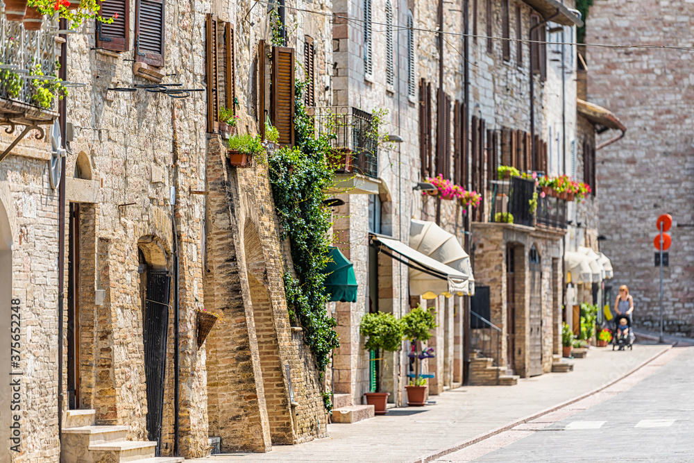Assisi, Italy city in Umbria sunny summer day with stone architecture and road street in historic St Francis town village