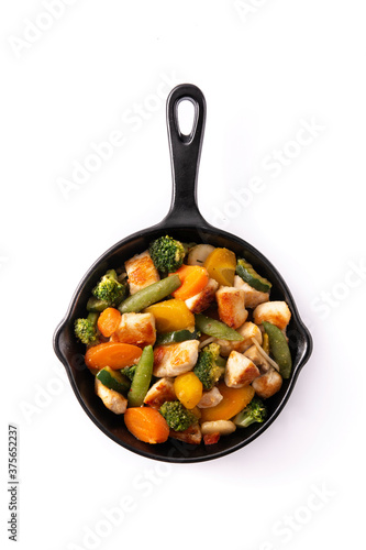 Stir fry chicken with vegetables on iron pan isolated on white background. Top view