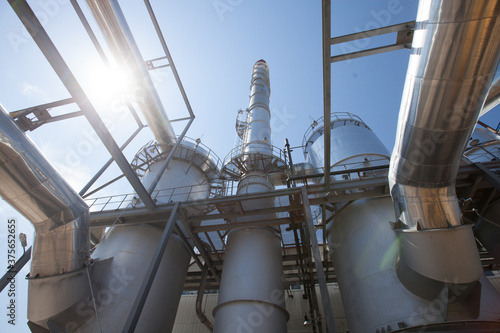 Sulphuric acid plant. Furnace for sulfur burning, tubes for sulphur dioxide. Smoking stack (factory chimney). Blue sky and sun background. Kzylorda region, Kazakhstan