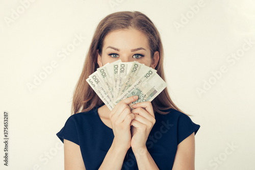 Anonimowa młoda kobieta trzyma gotówkę - kredyt, hipoteka, pożyczka, hazard, mieszkanie dla młodych, finanse