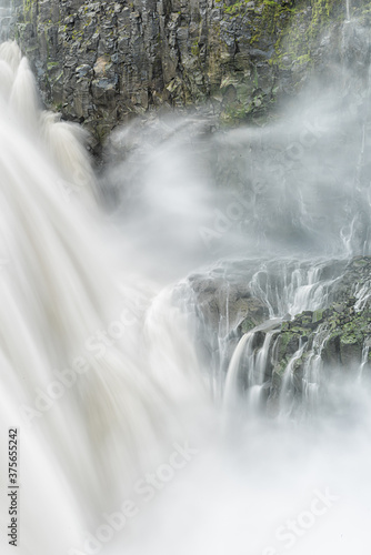 Icelandic Dettifoss waterfall falls vertical in Iceland gray long exposure smooth water in motion and rocky cliff spraying