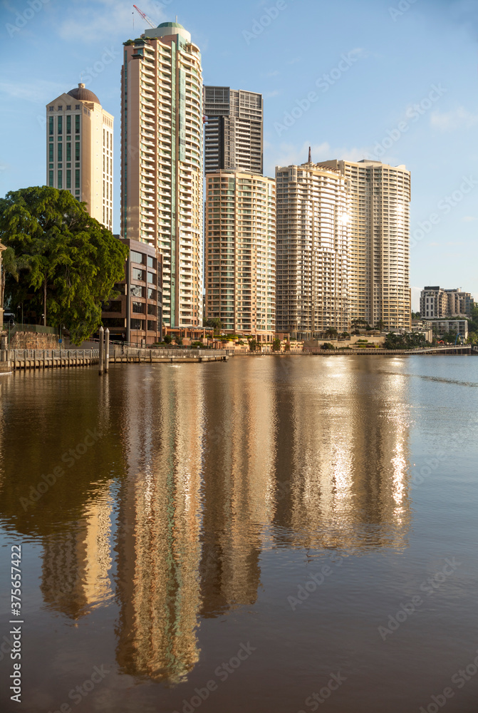 Waterfront apartments reflected in river at sunrise Waterfront apartments reflected in river at sunrise