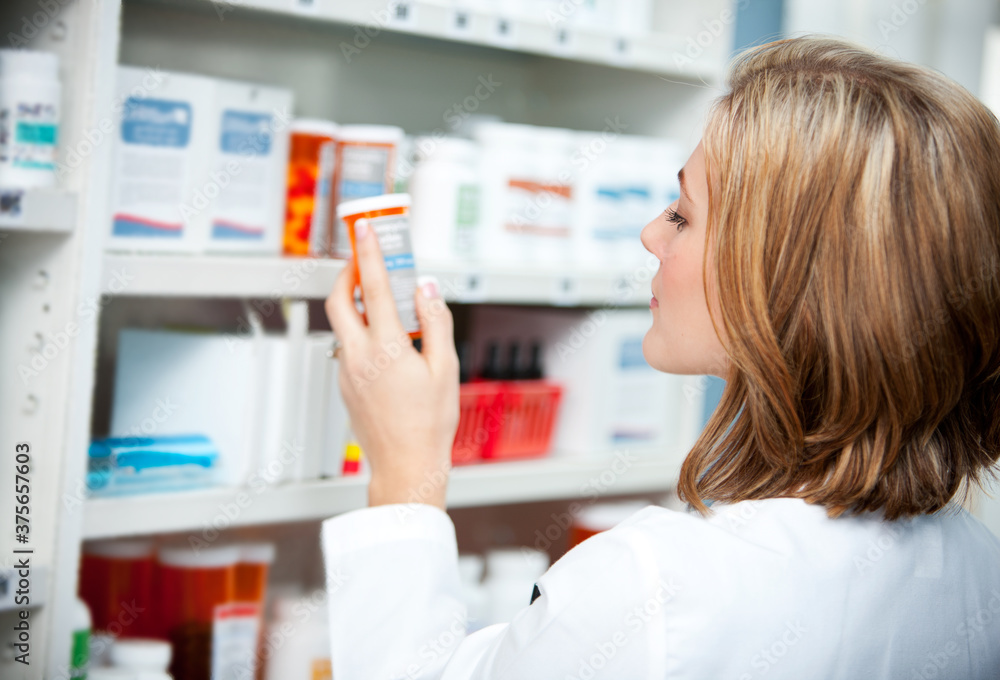Pharmacy: Pharmacist Looking at Medicine Instructions Pharmacy: Pharmacist Looking at Medicine Instructions