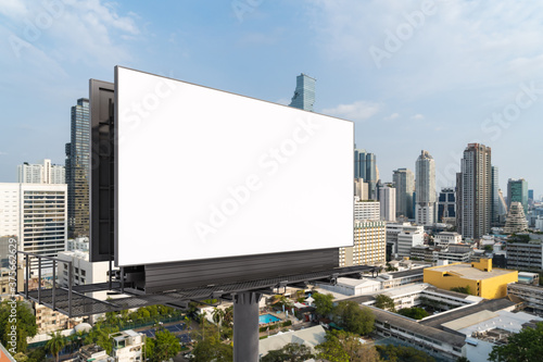 Blank white road billboard with Bangkok cityscape background at day time. Street advertising poster  mock up  3D rendering. Side view. The concept of marketing communication to promote or sell idea.