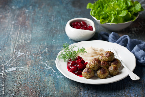 Meatballs with cranberry sauce and mashed potatoes or cauliflower, selective focus