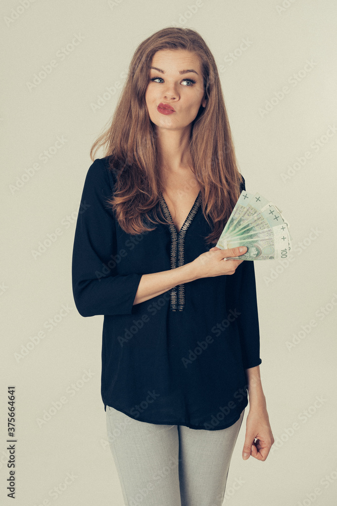 Anonimowa młoda kobieta trzyma gotówkę - kredyt, hipoteka, pożyczka, hazard, mieszkanie dla młodych, finanse - obrazy, fototapety, plakaty 