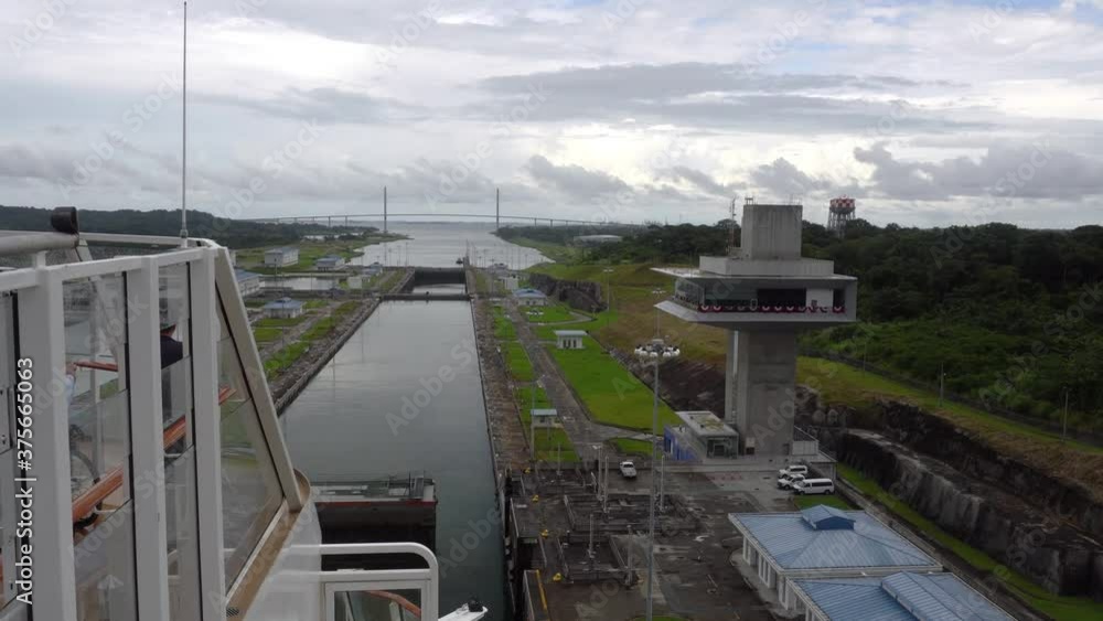 Panama Canal / Panama - November 2019: A view from the ship. Ship is entering locks and passing by the control tower. Panama Canal / Panama - November 2019: A view from the ship. Ship is entering locks and passing by the control tower.