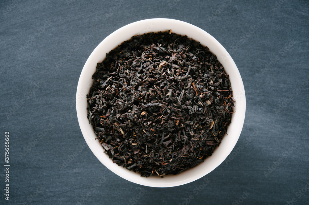 Bowl of Loose Black Assam Tea Presented on a Black Chalkboard Surface Bowl of Loose Black Assam Tea Presented on a Black Chalkboard Surface