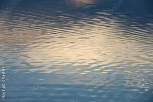 The calm water surface with reflections of different colors. Background.