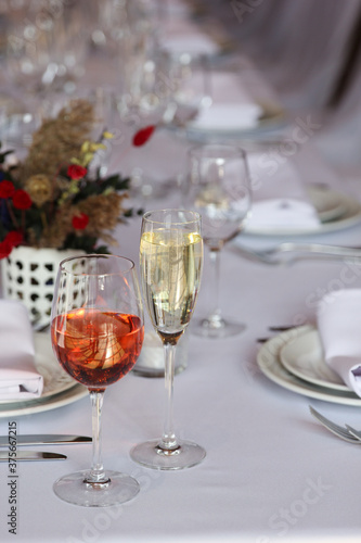 Wedding service. Festive table  wine glasses  white tablecloth. Plates and cutlery