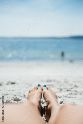 Woman's legs on a sandy beach in summer photo
